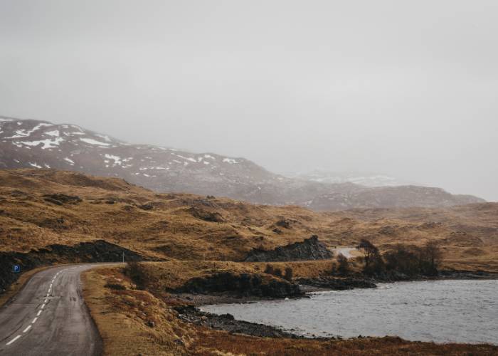 Road through the snow-covered Scottish Highlands near Lochinver on a misty winter's day