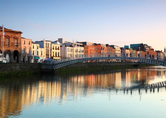 The Ha'penny Bridge, an iconic white wrought-iron pedestrian bridge, spans the River Liffey in the heart of Dublin