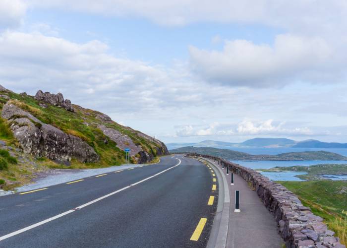 Panoramic view of the Ring of Kerry road, winding through lush green landscapes, illustrating Ireland's natural beauty and rich geography.