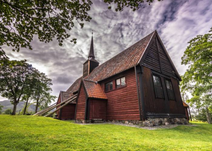 Standing wooden church of Kvernes, Norway's only post-medieval stavkirke, overlooking the fjord with its characteristic supporting beams.