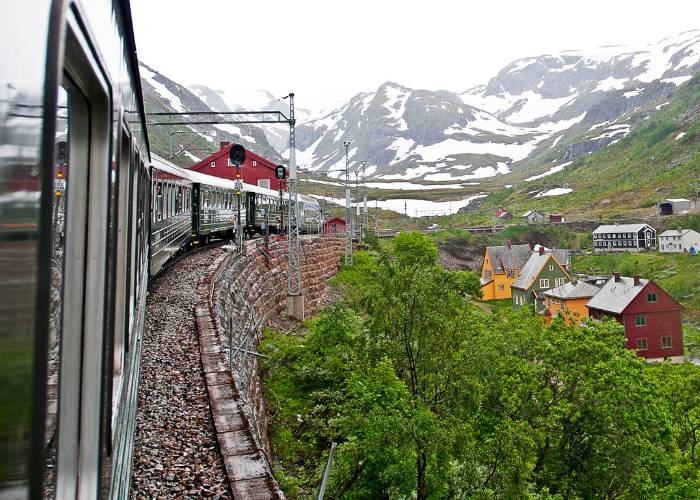 Le train de la ligne ferroviaire Flåm passe au-dessus des champs enneigés de Norvège