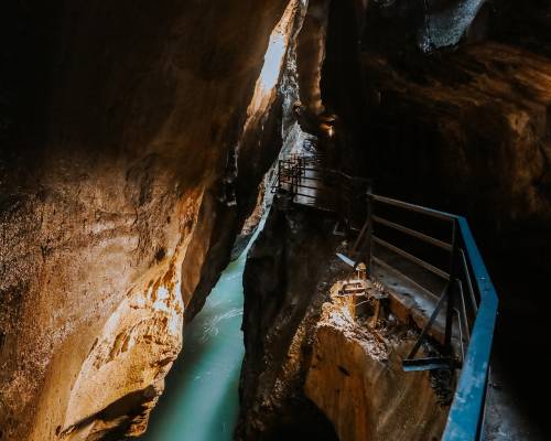 Accessible footbridge across the Aare Gorge in Switzerland, surrounded by imposing rock faces and located in the mountainous Bernese Oberland region