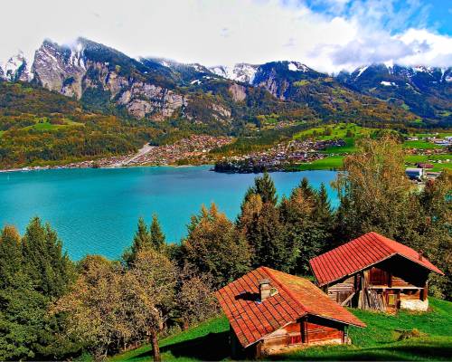 Panoramic view of Lake Brienz and its turquoise waters in the Swiss Alps, surrounded by lush green mountains, typical of the Bernese Oberland region